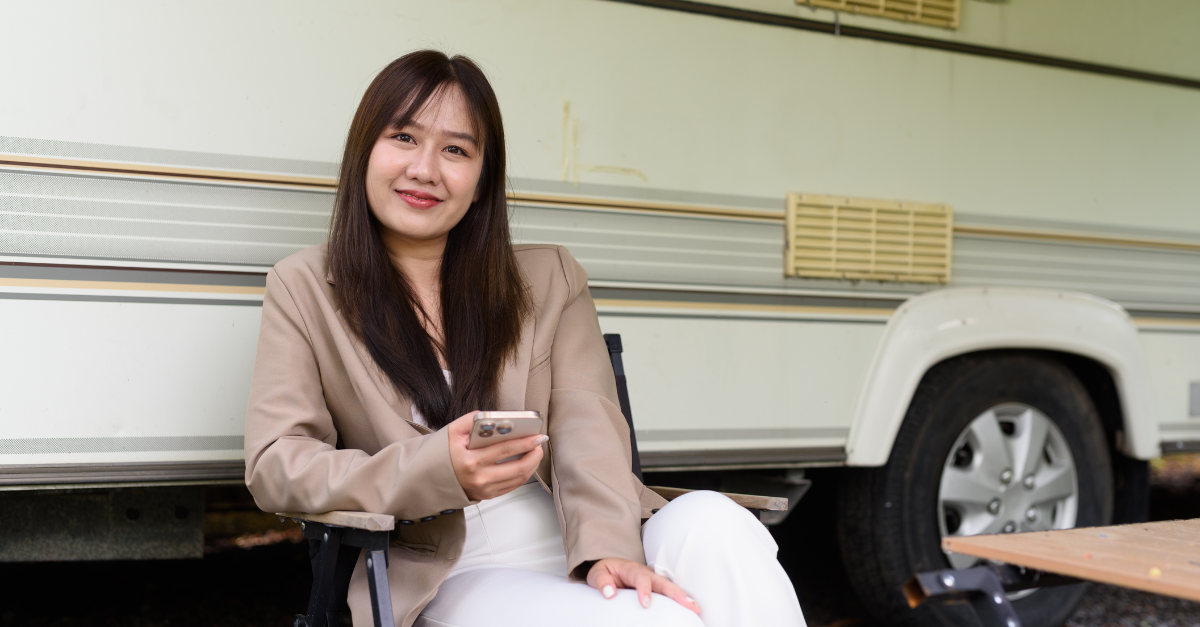 Young Asian woman camping in rv car while traveling