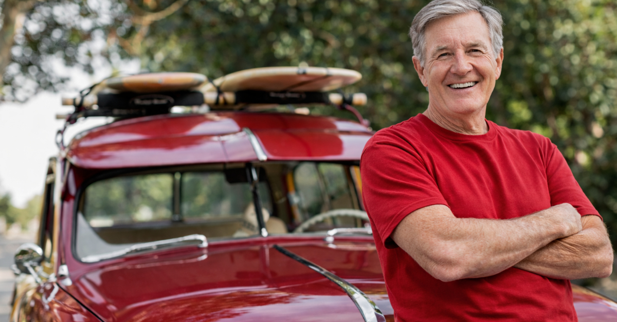 Smiling boomer man with vintage station wagon