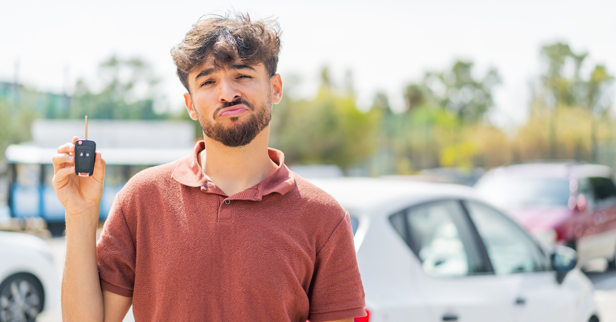 Young Arabian handsome man holding car key at outdoors with sad expression