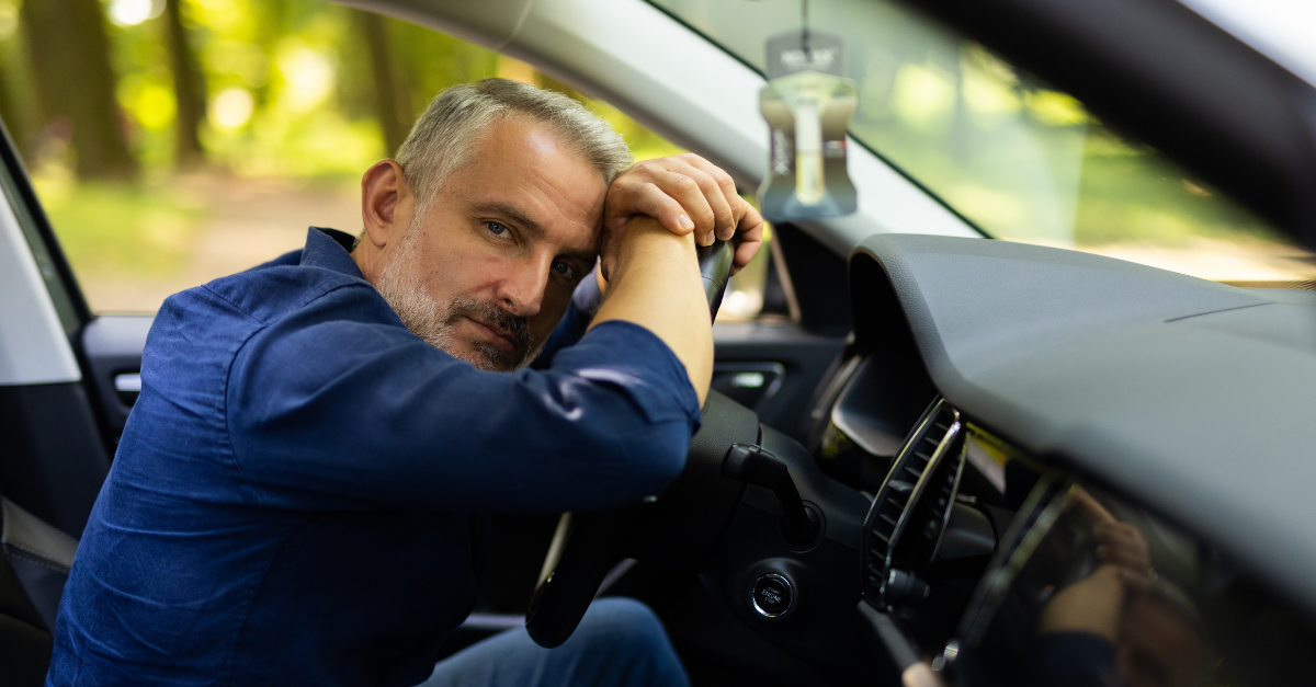 Young man sitting inside car is very upset and stressed