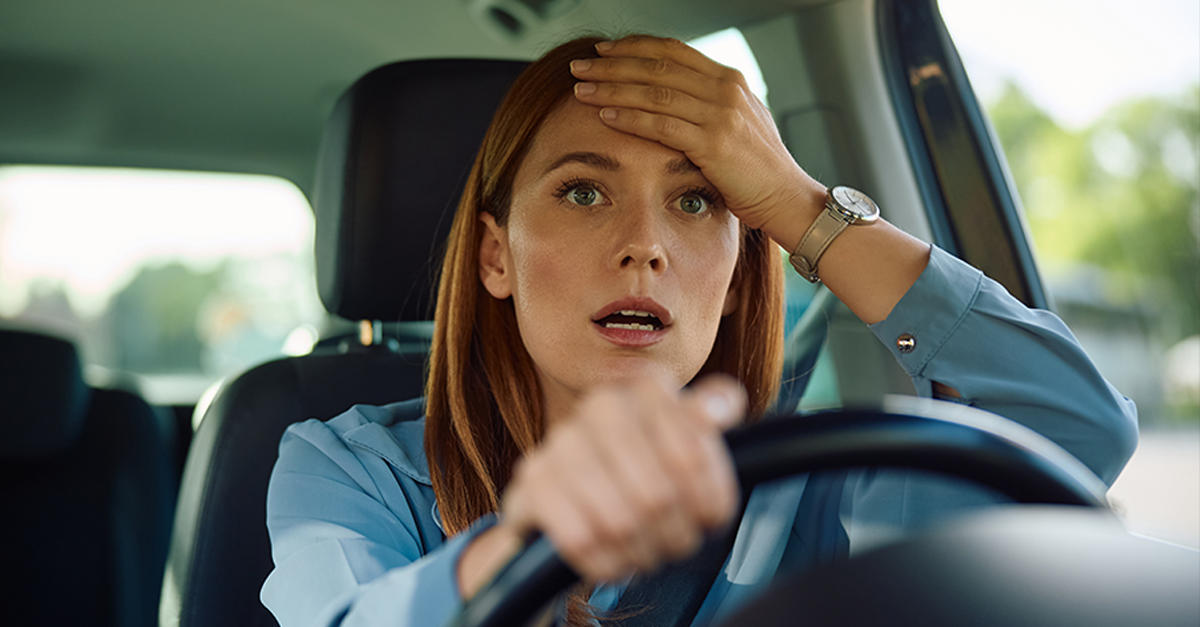 Shocked businesswoman driving a car