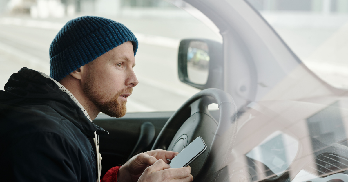 man-holding-his-smartphone-while-driving
