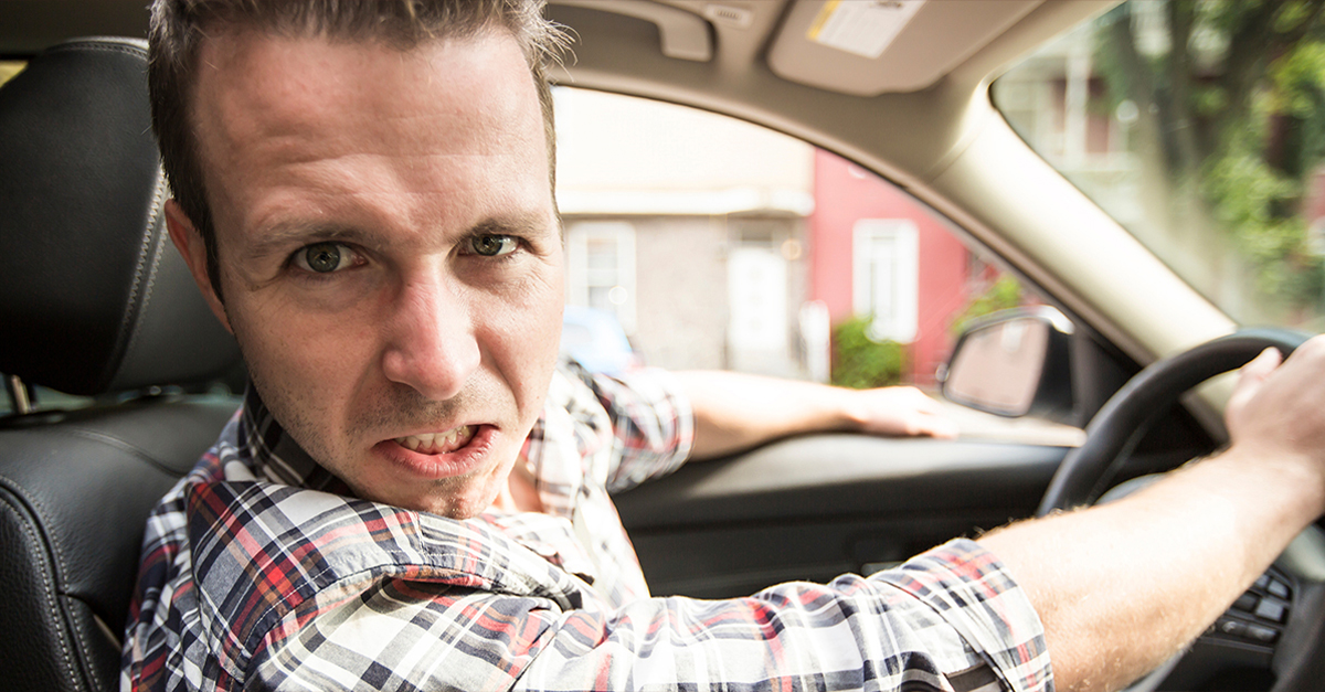 Irritated young man driving a car. Irritated driver