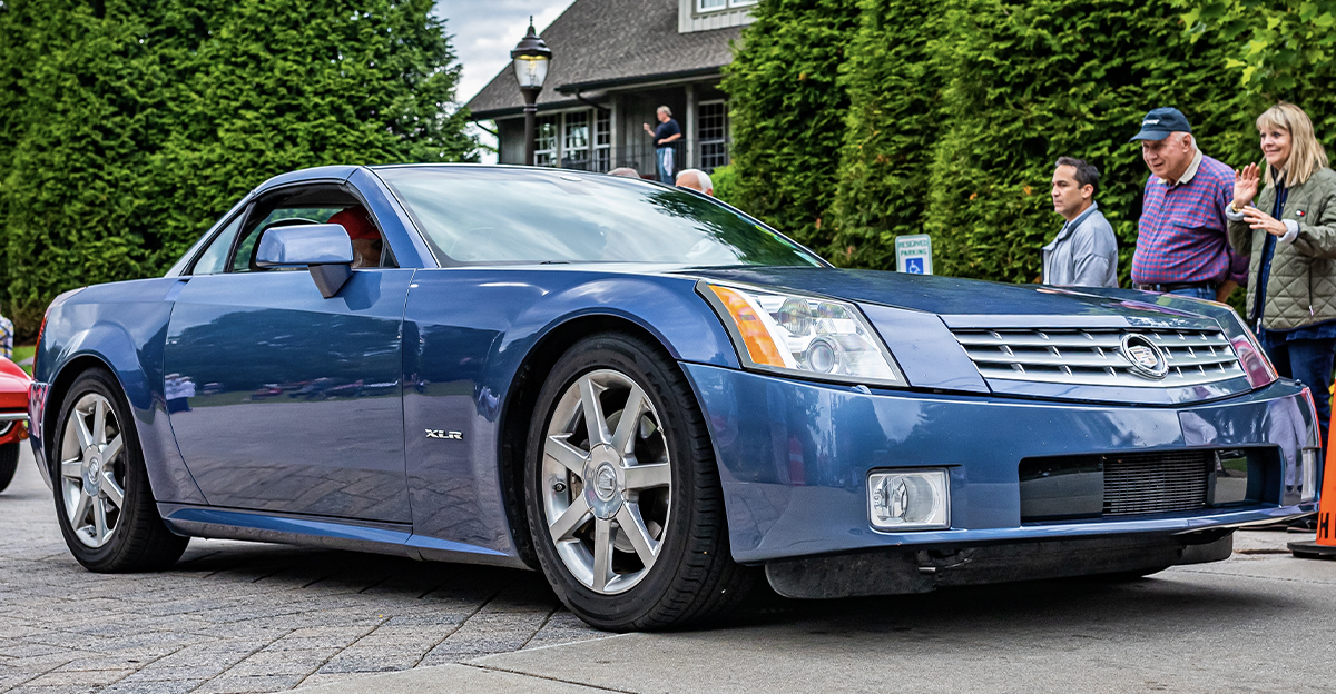 Low perspective front corner view of a 2004 Cadillac XLR Hardtop Coupe leaving a local car show.